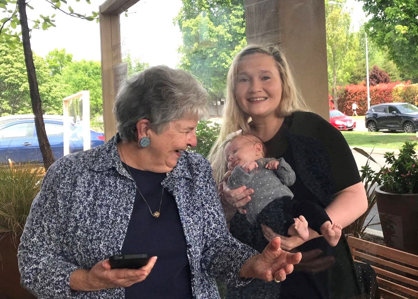 Meeting a grandchild for the first time behind The Springs Living's visitor safety glass during the COVID-19 pandemic