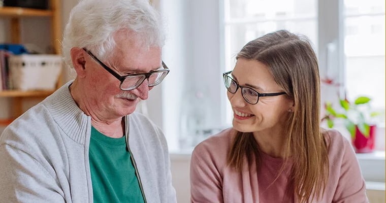 Adult daughter visiting her senior father at home and using tablet copy