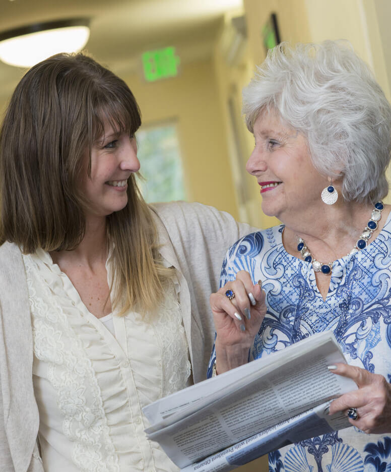 Resident with young woman reading a newspaper