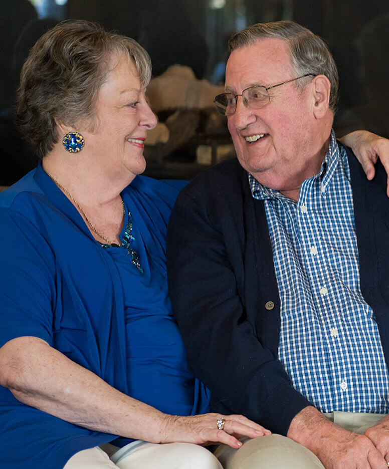 Resident couple by the fireplace at the Wilsonville community