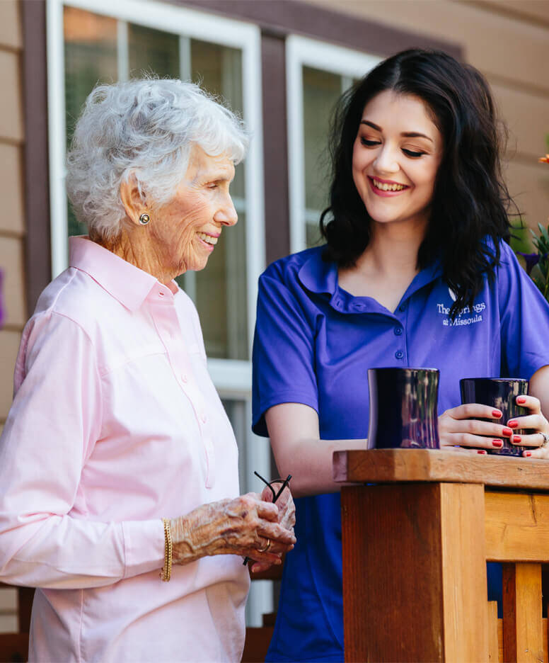 Care giver chatting over coffee with a resident at the Missoula community