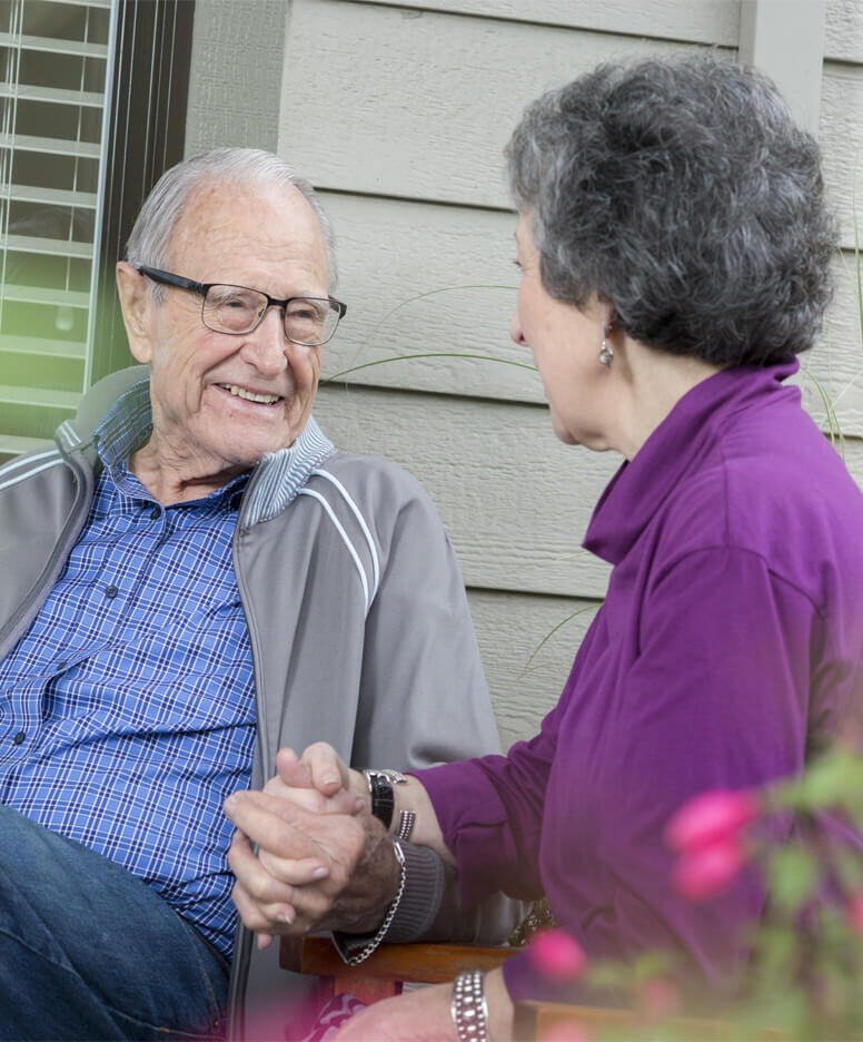 Couple sitting and holding hands at the Veranda Park community