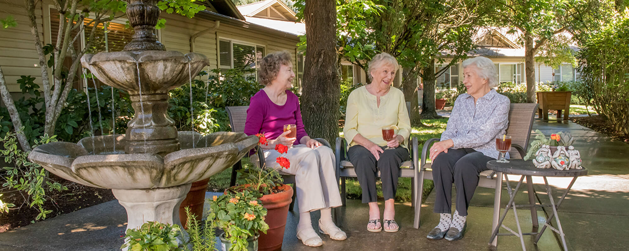 Three residents drinking tea on the terrace at the Wilsonville community