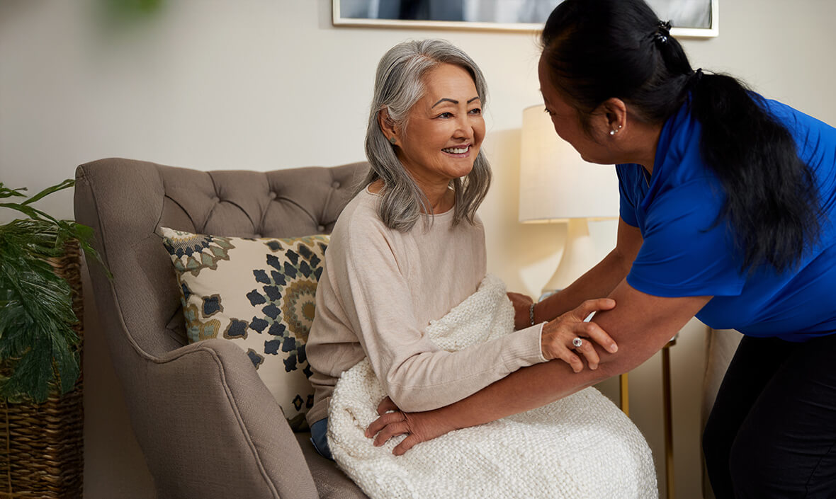 Woman placing a blanket on another woman