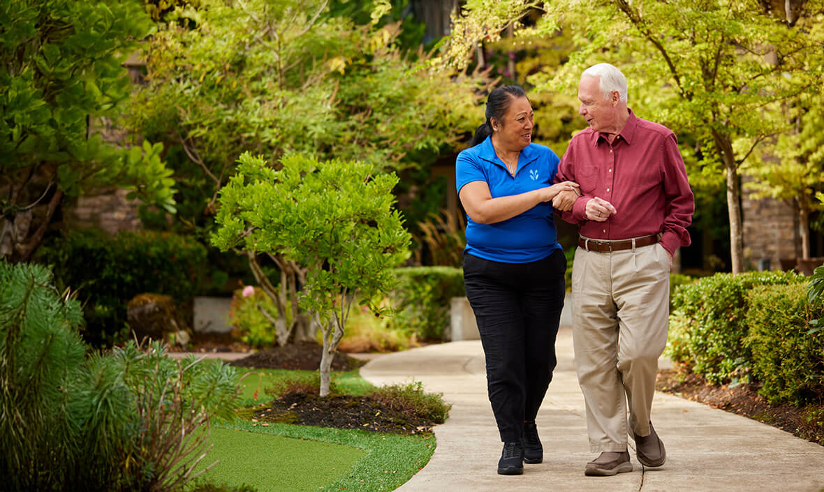 Man and woman walking down a path arm in arm