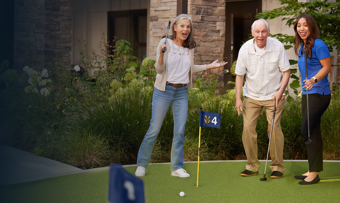 Man and two women putting golf balls