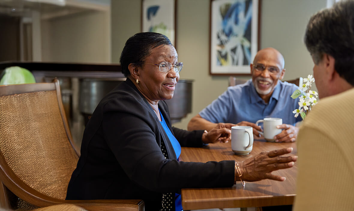 Two women and a man having coffee together