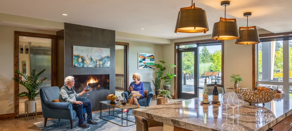 Two residents sitting by a fireplace at The Springs at The Waterfront in Vancouver, Washington