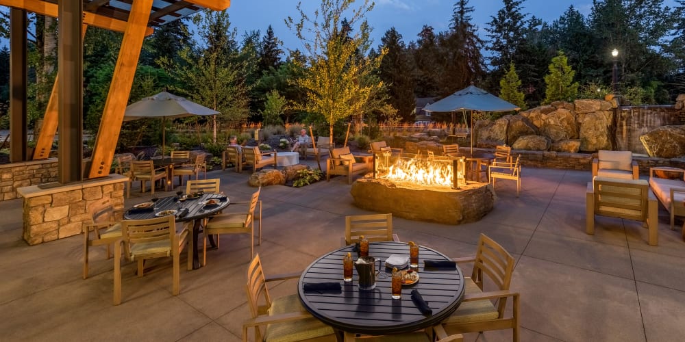 warmly lit patio with covered seating and a fire pit at The Springs at Lake Oswego in Lake Oswego, Oregon