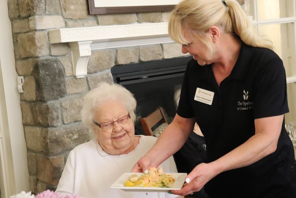 Resident being served a meal by caregiver at The Springs at Grand Park in Billings, Montana