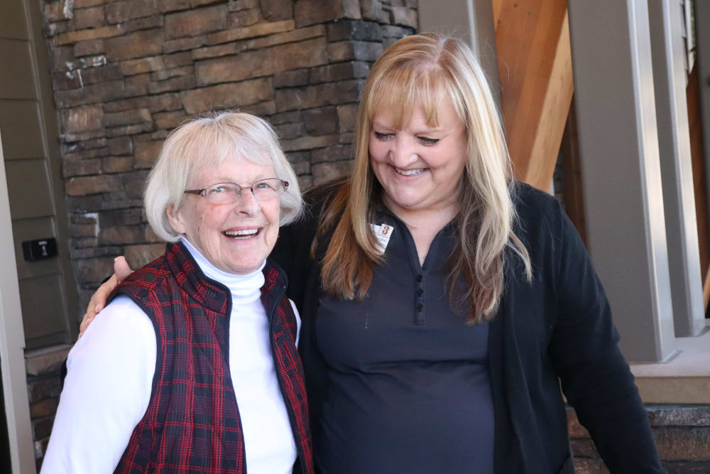 Resident smiling with caregiver at The Springs at Greer Gardens in Eugene, Oregon.