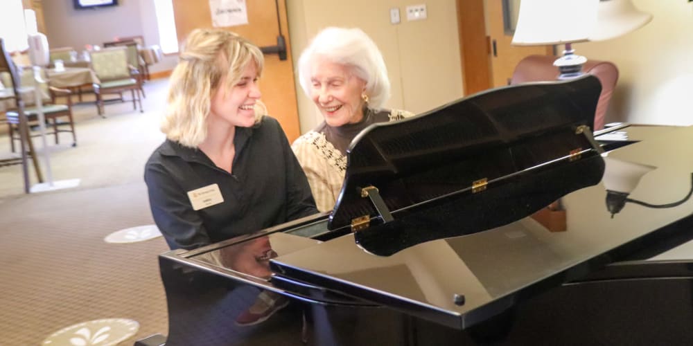 Resident playing the piano with a caregiver at The Springs at Mill Creek in The Dalles, Oregon