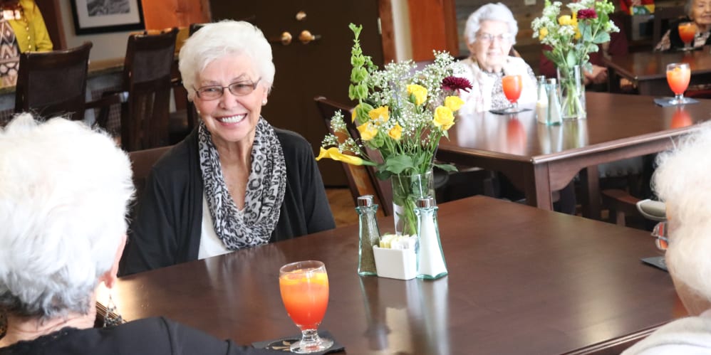 Resident smiling over a meal at The Springs at Butte in Butte, Montana