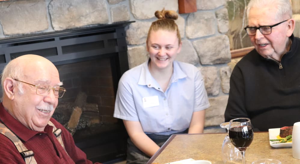 Two residents dining with a caregiver at The Springs at Butte in Butte, Montana