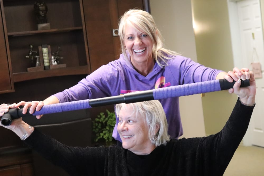 Resident and caregiver having fun participating in an exercise class at The Springs at Butte in Butte, Montana