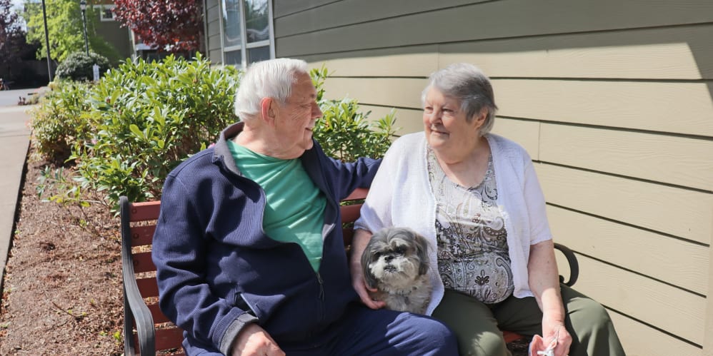 Residents enjoying sitting outside with their dog at The Springs at Clackamas Woods in Milwaukie, Oregon