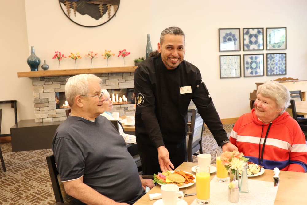 Residents being served a meal by chef at The Springs at Clackamas Woods in Milwaukie, Oregon.