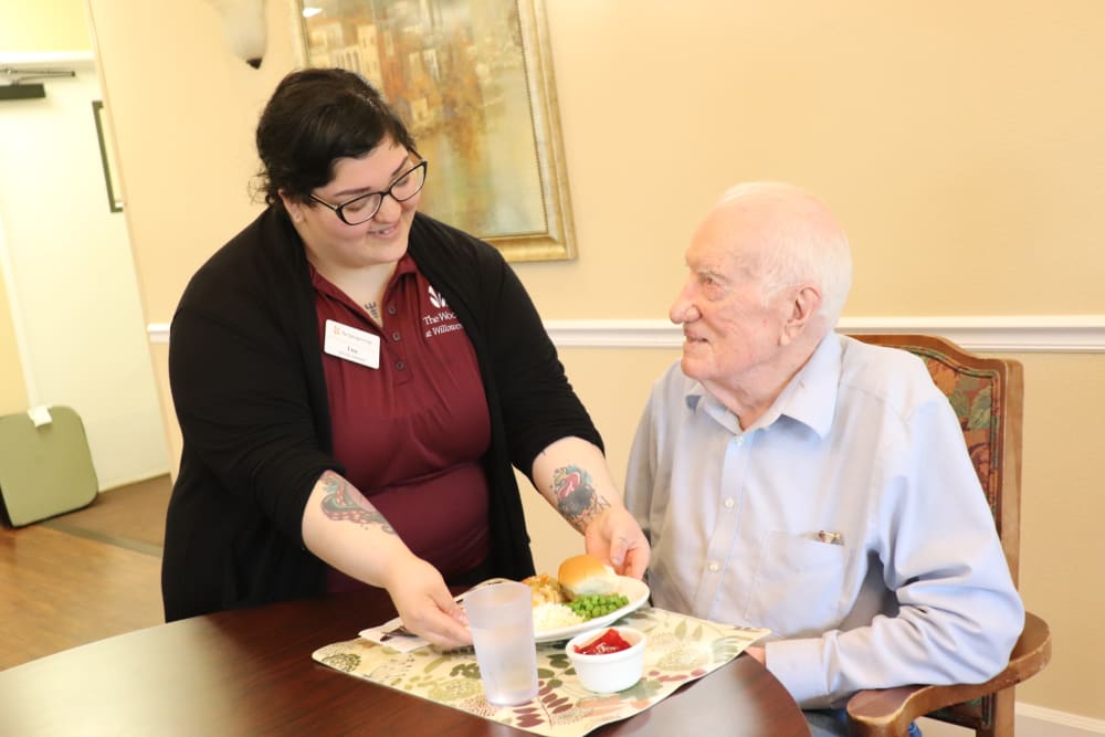 Caregiver with resident enjoying a meal at The Springs at Willowcreek in Salem, Oregon