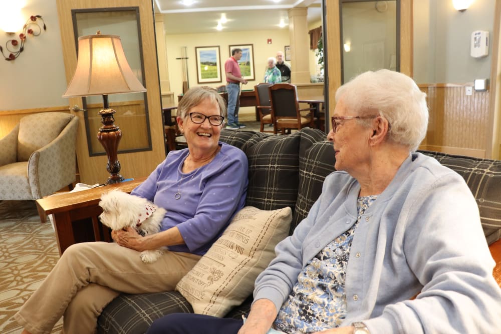 Residents chatting in the lounge area while one holds their little dog at The Springs at Sunnyview in Salem, Oregon
