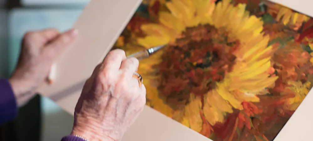 Resident painting picture of sunflower at The Springs at Tanasbourne in Hillsboro, Oregon