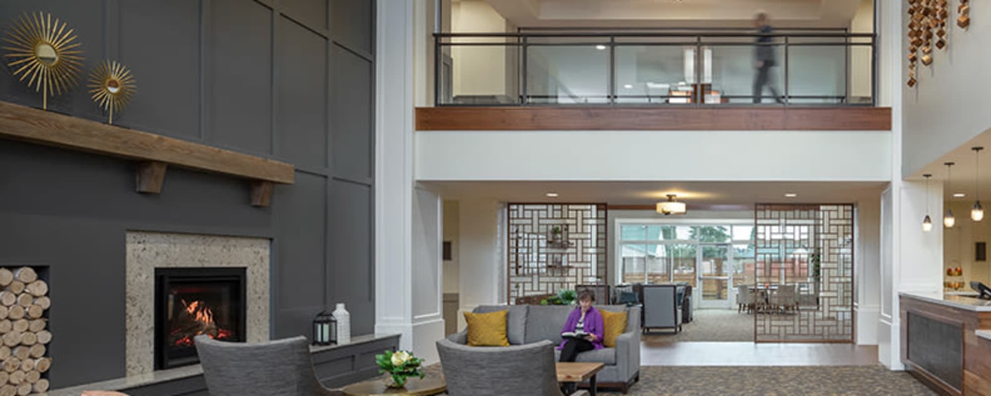 Elegant and well lit common area of upscale senior living area, complete with comfy arm chair and wood accents at  The Springs at Sherwood in Sherwood, Oregon