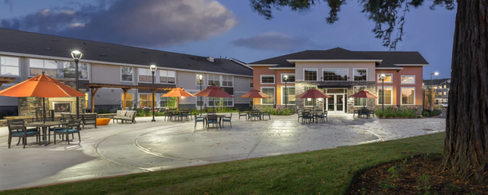 Back patio of upscale senior living facility with cheerful orange umbrellas at The Springs at Sherwood in Sherwood, Oregon