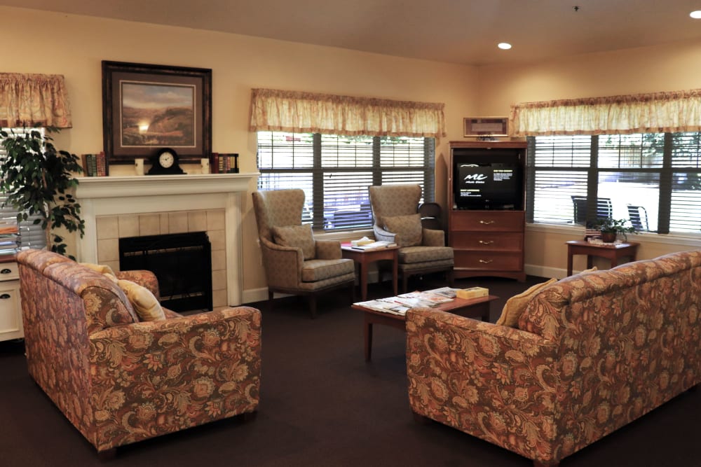 Charming sitting area complete with comfortable sofas, television set, and fireplace in upscale senior living facility at The Springs at Willowcreek in Salem, Oregon