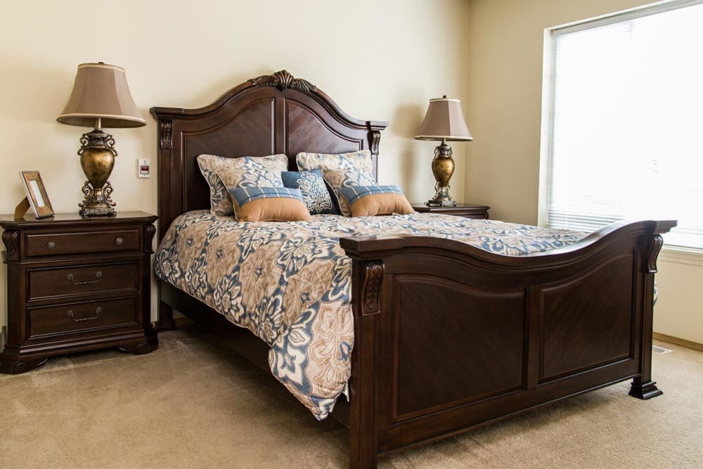 Bedroom with luxurious woods accents at upscale senior living facility at The Springs at Butte in Butte, Montana