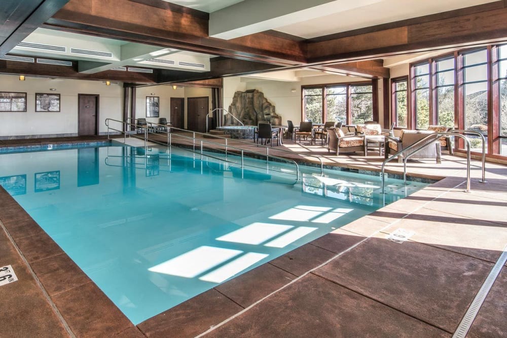 Sun shines into gorgeous indoor pool area with plenty of relaxation space at The Springs at Carman Oaks in Lake Oswego, Oregon