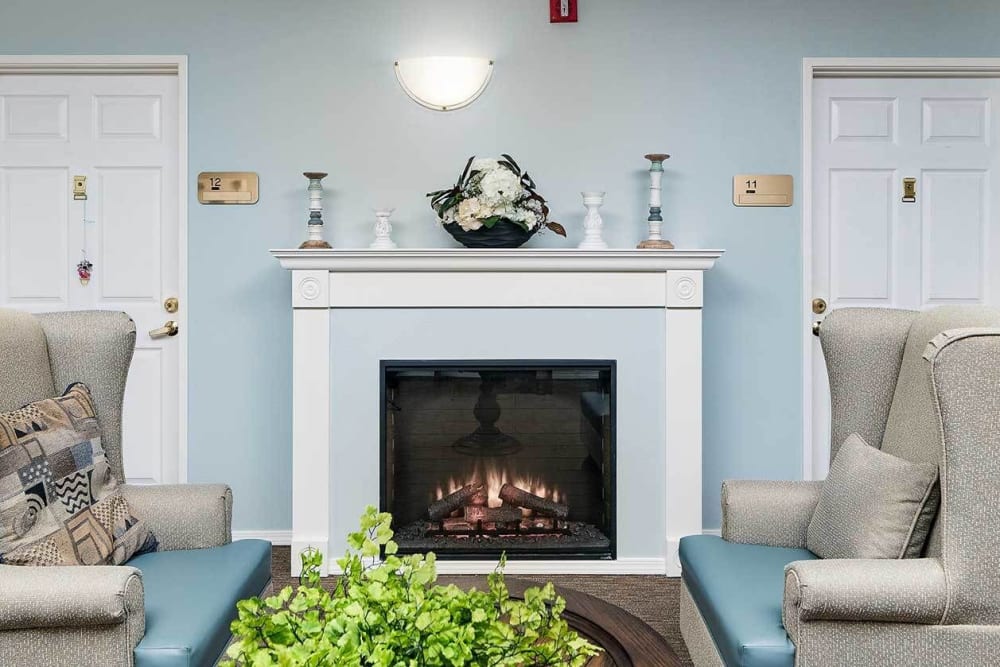 Fireplace seating in a calming blue room with comfy arm chairs at The Springs at Grand Park in Billings, Montana