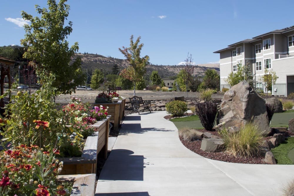 Sunny and inviting walk up to upscale senior living facility complete with fushia flowers at The Springs at Mill Creek in The Dalles, Oregon