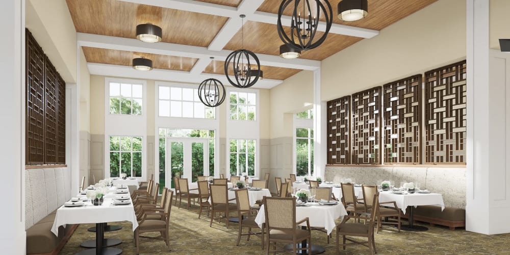 Brightly lit upscale senior dining room with modern chandelier and wood accents at The Springs at Sherwood in Sherwood, Oregon