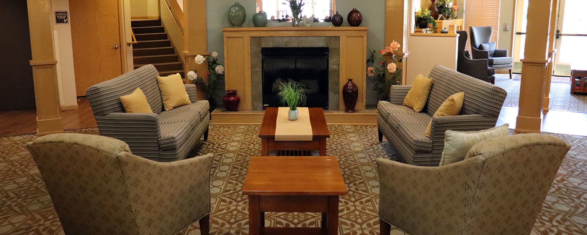 Cheerful lounge seating complete with wood accents and fireplace in upscale senior living facility at The Springs at Sunnyview in Salem, Oregon