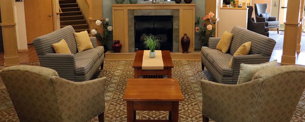 Welcoming upscale lounge seating with comfy armchairs,  flowers and fireplace at The Springs at Sunnyview in Salem, Oregon