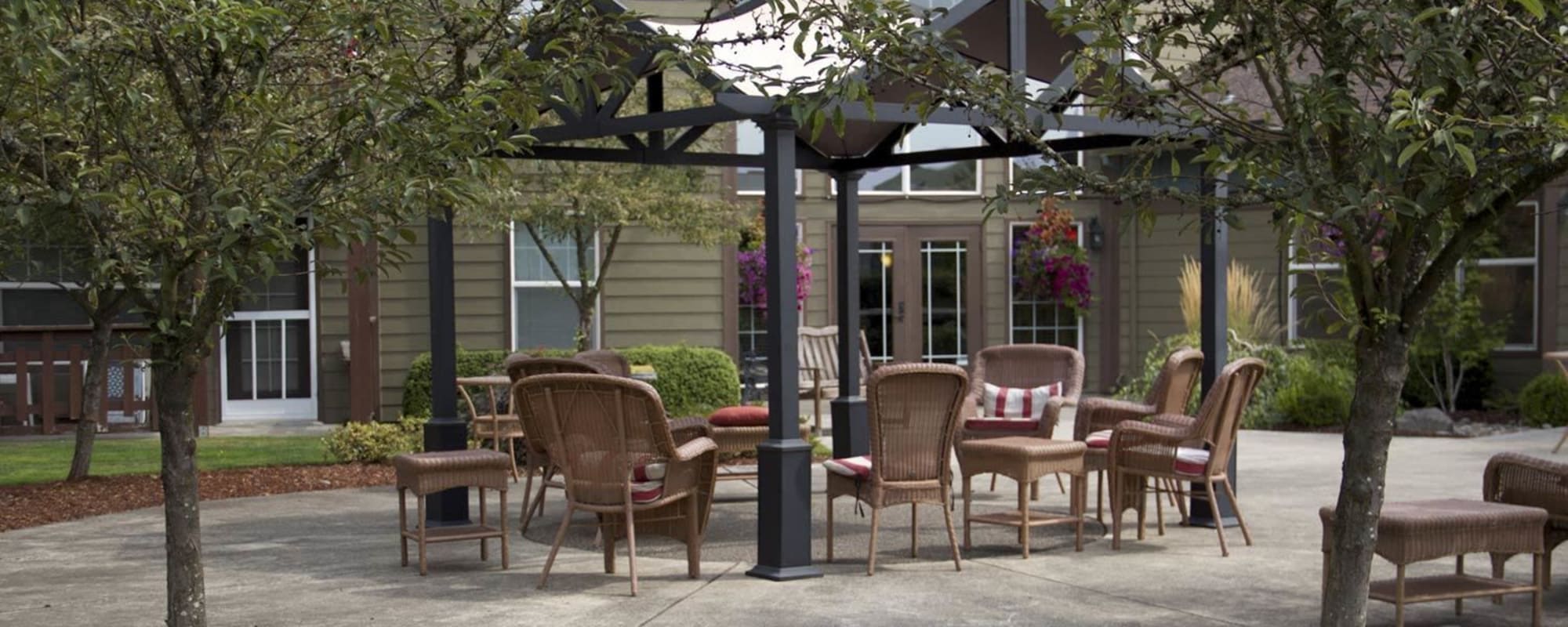 Patio seating outside on a sunny day complete with wicker furniture at The Springs at Sunnyview in Salem, Oregon