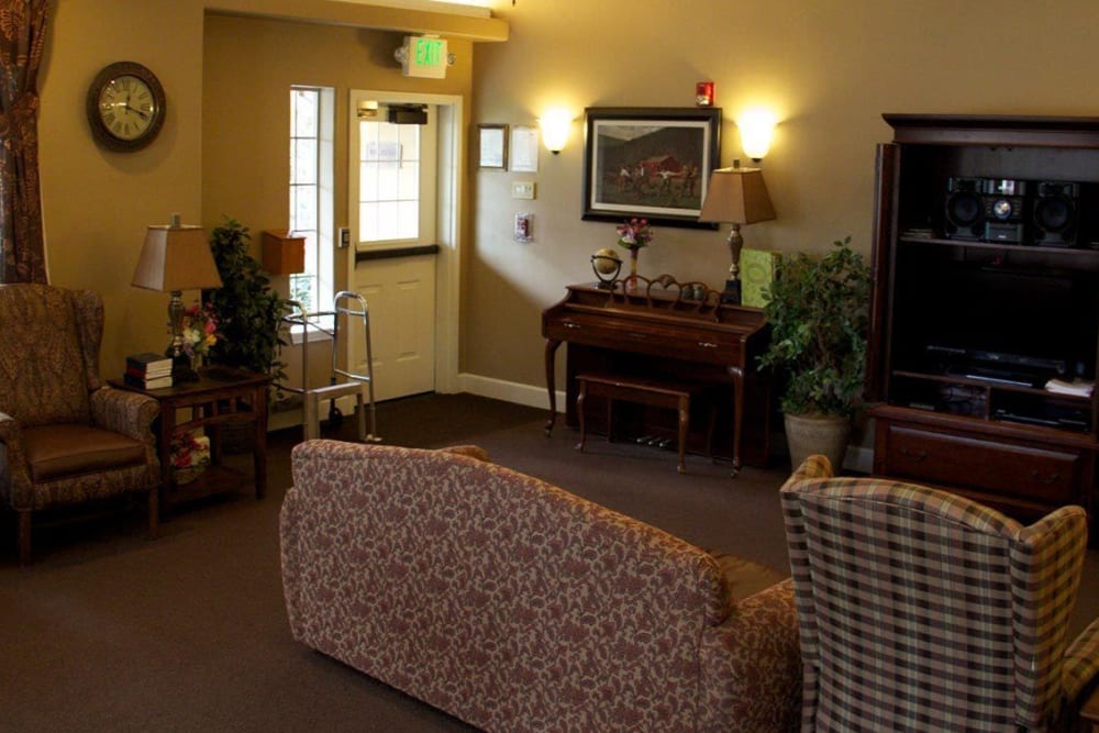 Front communal sitting area in upscale senior living facility complete with wood accented piano and armchairs at The Springs at Willowcreek in Salem, Oregon