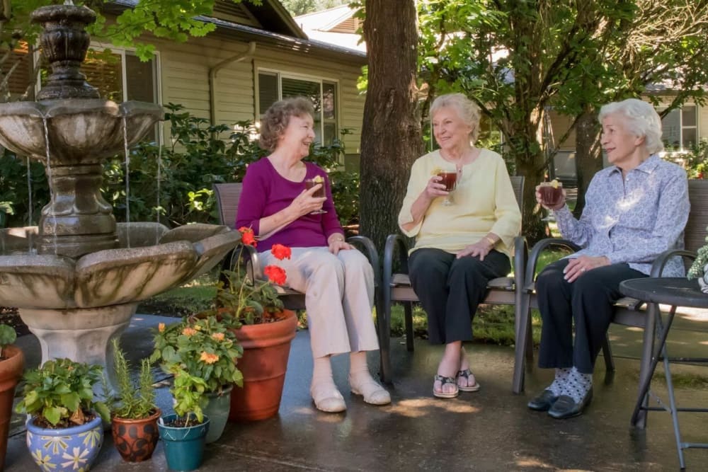 Residents enjoying ice tea near a fountain on outdoor patio at The Springs at Wilsonville in Wilsonville, Oregon