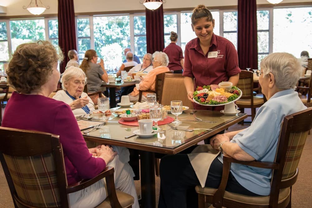 Dinning room server delivers delicious charcuterie board to residents at The Springs at Wilsonville in Wilsonville, Oregon