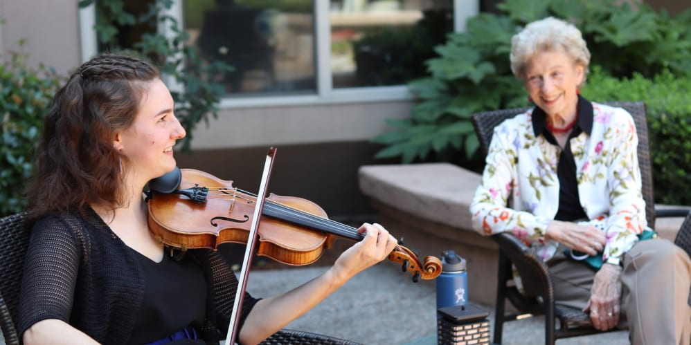 Resident enjoying violin music at The Springs at Anna Maria in Medford, Oregon