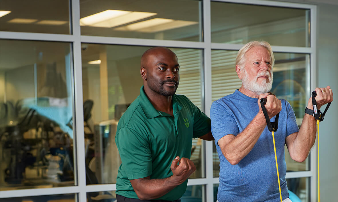 Physical therapist helping a man exercise
